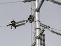 Des travailleurs chinois perchés sur la tour à haute tension pour réparer les câbles dans l’est de la Chine, province d’Anhui le 18 mars. Actuellement, il n’y a pratiquement aucune augmentation de la production d’électricité, indiquant un ralentissement de l’activité économique. (STR/AFP/GettyImages)
