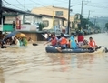 7 Août 2012, après des pluies torrentielles ayant inondé une majeure partie de la capitale, les sauveteurs utilisent des bateaux en caoutchouc pour  évacuer les habitants de leurs maisons submergées dans le village de Tumana, banlieue de Marikina, près de Manille. (Ted Aljibe/AFP/GettyImages)