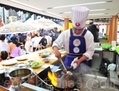 Un chef cuisine un plat chinois authentique à Times Square, durant la compétition internationale de cuisine chinoise de 2011. Cette année également des chefs de renom se joindront aux chefs chinois s’affrontant au wok à Times Square. (Dai Bing/Epoch Times) 