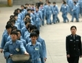 Prisonniers marchant au côté d’une escorte de police lors d’une journée porte ouverte des prisons à Nanjing en 2005. Récemment, les appels visant à démanteler le système des camps de travail en Chine se sont accrus. (STR/AFP/Getty Images) 