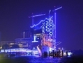 Un cargo est amarré en face de bâtiments illuminés en bleu lors de l’installation lumineuse biennale u00abHamburg Blue Port» à Hambourg, en Allemagne, le 13 Août 2012. L’OCDE a annoncé lundi qu’elle s’attend à ce que l’Allemagne jouisse d’un excédent de 200 milliards de dollars cette année, ainsi que  son premier bilan excédentaire avec la Chine depuis 1988. (Patrick Lux/Getty Images)