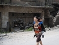 Cette photo, prise le 8 septembre 2012 à la frontière entre le Yunnan et le Guizhou, deux  provinces au sud-ouest de la Chine, montre une femme portant un enfant sur son dos dans une rue de Yiliang après deux tremblements de terre à une heure d’intervalle au milieu de la journée  suivis de plusieurs secousses. (STR/AFP/GettyImages)
