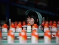 Un ouvrier observe les  bouteilles de boisson lactée Wahaha à l’usine du groupe de Wahaha, le 2 juillet 2012 à Hangzhou dans la province du Zhejiang. Les récentes statistiques économiques chinoises montrent  une surcapacité dans le secteur industriel et une augmentation des prix à la consommation. (Feng Li/Getty Images)
