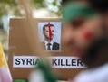 Un panneau dénonçant les crimes de  Bachar el-Assad affiché lors d’un rassemblement de l’opposition autour du président iranien Ahmadinejad à l’Assemblée générale des Nations Unies le 26 septembre 2012, à New York. (Mario Tama/Getty Images) 