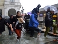 Les gens marchent dans une rue inondée lors d’une crue, le 11 novembre 2012 à Venise, en Italie. La Banque mondiale a mis en garde face à une augmentation d’inondations, de sécheresses, de vagues de chaleur etc. au cours du siècle prochain si aucune action drastique n’est mise en place. (Marco Sabadin/AFP/Getty Images)