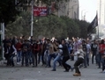 25 novembre, au Caire, les manifestants égyptiens lancent des pierres en direction de la police anti-émeute lors d’affrontements sur la place Tahrir. Dimanche, le Président Mohamed Morsi a tenté de calmer les manifestants rassemblés contre le récent décret élargissant nettement son pouvoir. (Gianluigi Guercia/AFP/Getty Images)