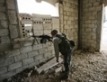 17 novembre 2012, ville de Maaret Al-Numa, un tireur du côté des rebelles observe les  positions de l’armée située à environ 2.000 mètres. (Jean Cantlie/AFP/Getty Images)