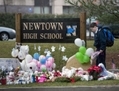 Un élève dépose des fleurs sur le mémorial improvisé pour les victimes de la fusillade de l’école primaire Sandy Hook, à l’entrée de l’école à Newtown, CT, le 18 décembre 2012. (Brendan Smialowski/AFP/Getty Images)