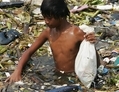 MANILLE, Philippine. Un garçon ramasse des déchets plastiques dans les ordures flottant sur l'eau à proximité de Roxas le long de la baie de Manille. (China Photos/Getty Images)
