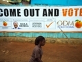 Une femme passe devant une affiche électorale du candidat à la présidence, Raila Odinga, dans un taudis de la capitale Nairobi. (Phil Moore/AFP/Getty Images)