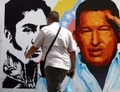 Un homme passe devant une peinture murale représentant le Président Hugo Chavez et le libérateur de l’Amérique du Sud Simon Bolivar dans le quartier du 23 de Enero à Caracas le 5 mars 2013. Chavez est mort mardi à l’âge de 58 ans (Geraldo Caso/AFP/Getty Images)