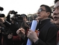 Jackie Chan, une star de films d’arts martiaux de Hong Kong, entouré par des journalistes lors de sa participation à la CCPPC. (STR/AFP/Getty Images) 