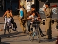 Des enfants circulent à vélo à Srinagar, Cachemire, alors que des policiers contrôlent la circulation. (Paula Bronstein/Getty Images)