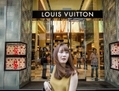 Une cliente passe devant un magasin Louis Vuitton à Hong Kong en septembre 2012. L’année dernière, les consommateurs chinois ont dépassé les consommateurs américains, devenant les premiers acheteurs de produits de luxe du monde. (Philippe Lopez/AFP/Getty Images)