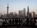 Les touristes regardent le coucher de soleil sur le quartier financier de Pudong à Shanghai le 15 avril. La croissance économique chinoise a ralenti à 7,7% au premier trimestre, les données ont montré, contrairement aux attentes et aux préoccupations logistiques que la reprise récente chancelle du fait d’une demande modérée à l’étranger. (Mark Ralston/Getty Images)