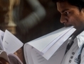 Un jeune Indien consulte des documents en patientant dans une file d’attente lors d’un salon de l’emploi à Mumbai le 12 octobre 2011. Depuis peu, les sociétés indiennes organisent une collecte d’informations personnelles sur les demandeurs d’emploi avant leur embauche. (Punit Paranjpe/AFP/Getty Images)