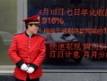 Un guide debout en face d'un tableau électronique à l'entrée d'une banque à Pékin le 23 avril 2013. La Chine est confrontée à une crise bancaire totale alors qu’explosent les taux interbancaires, un rapport affirme que la Banque populaire de Chine a dû intervenir le 20 Juin 2013, pour renflouer une banque non identifiée. (Wang Zhao/AFP/Getty Images)