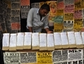 Dans une boutique d’Hyderabad, en Inde, en février 2012, un commerçant indien vend des formulaires pour répondre à des offres d’emploi. Selon une étude, l’Inde serait le pays avec le taux le plus élevé de départ des employés à l’international au niveau mondial, avec un taux de 26,9 % pour l’année à venir. (AFP PHOTO/Noah SEELAM) 