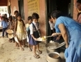 Les écoliers indiens reçoivent un repas gratuit à l’école, dans l'État du Bihar, en Inde, le 18 juillet 2013. À la suite du décès de 23 enfants dans une école primaire de l’État du Bihar, la police a intensifié son enquête et n’écarte pas l’éventualité d’un empoisonnement délibéré des repas gratuits délivrés aux enfants. (STRDEL/AFP/Getty Images)
