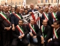 Ugo Cappellaci, président du gouvernement sarde (au centre, tenant un drapeau) pose avec les maires sardes, le 24 juin 2013, devant le bâtiment du Parlement italien, afin de demander une Zone Franche couvrant l’île de Sardaigne. (Andrea Lorini/Epoch Times)
