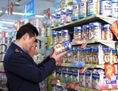 Des représentants des forces de l’ordre vérifient les dates sur les boîtes de lait en poudre dans une boutique de Tongzi, dans la région du Guizhou en Chine du sud-ouest, le 9 février 2010 alors que les produits laitiers, contenant de la mélamine chimique industrielle, tournent à nouveau dans les magasins. La Chine recherche près de 100 tonnes de lait en poudre contaminé qui devrait avoir été détruit après un scandale en 2008, suite à la mort de six bébés. (AFP/Getty Images)
