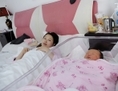 Une mère contemplant son bébé allongée sur son lit dans une salle de la maternité de l’Hôpital Antai de Pékin, le 28 novembre 2012. La proportion de mères chinoises choisissant des césariennes a plus que doublé en moins d’une décennie, passant d’environ 20% en 2001 à plus de 46% en 2007 – et approchant les deux-tiers dans les villes, à en croire les derniers chiffres de l’Organisation Mondiale de la Santé pour le pays. (Wang Zhao/AFP/Getty Images)