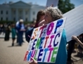 Une femme tient une affiche lors d’une manifestation contre Monsanto et les organismes génétiquement modifiés (OGM) en face de la Maison-Blanche, le 25 mai 2013. (Nicholas Kamm/AFP/Getty Images)