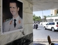 À Damas, le 9 octobre 2013, un véhicule de l’ONU qui transporte des inspecteurs de l’Organisation pour l’interdiction des armes chimiques (OIAC) quitte l’hôtel et passe devant une affiche du président syrien Bachar Al-Assad, collée sur un mur. (Louai Beshara/AFP/Getty Images) 