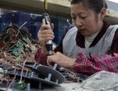 Le 2 Avril 2011, une femme au travail dans une usine de la province du Fujian au sud-est de la Chine. Même les simples appareils électroniques fabriqués en Chine peuvent arriver avec une petite surprise: un dispositif destiné à faciliter la cybercriminalité. (STR/AFP/Getty Images)