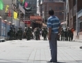 L’attaque de la station de police du Xinjiang est le dernier violent incident en date dans cette région agitée du nord-ouest de la Chine. Ici on voit un Ouïgour regarder des policiers chinois bloquer une rue le 9 Juillet 2009 à Urumqi, la capitale de la région autonome ouïgoure du Xinjiang, en Chine. (Guang Niu/Getty Images)
