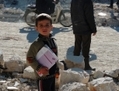 Un jeune écolier se tient à l’extérieur de son établissement, ses livres en main ce 22 décembre. Son école située au nord de la ville de Marea à la périphérie d’Alep en Syrie, vient de subir des attaques aériennes des forces gouvernementales syriennes. Selon un observateur, plusieurs dizaines de personnes ont été tuées les huit jours des raids. (Mohammed Al-Khatieb/AFP/Getty Images)