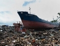 Un cargo rejeté sur le rivage par le Super Typhon Haiyan, repose sur des débris et les ruines des maisons détruites plusieurs semaines après la tempête qui a frappé la ville côtière de Tacloban, dans la province de Leyte, le 24 décembre 2013. (Ted Aljibe/AFP/Getty Images) 