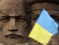 Un drapeau ukrainien flotte devant le monument des agents du KGB à Kiev, Ukraine, le 23 février 2014. Le gouvernement agit. (AP Photo/Darko Vojinovic)