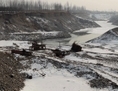 Des pièces de machines abandonnées dans la rivière Juma suite à des opérations d’extraction de gravier le 8 janvier 2013. De nombreux cours d’eau en Chine sont  très contaminés par les déchets toxiques. (STR/AFP/Getty Images)