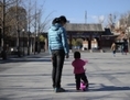 26 novembre 2013: Une femme et son enfant marchent dans un parc de Pekin. Les autorites du planning familial chinois ont recemment rejete la demande de compensation des parents ayant perdu leur enfant unique. (Wang Zhao/AFP/Getty Images) 