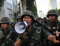 Des soldats thaïlandais contrôlent une foule manifestant contre le coup d’État le 23 mai 2014 à Bangkok. (Rufus Cox/Getty Images)