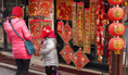 Une mère et sa fille achètent des décorations traditionnelles à l’occasion du nouvel an chinois. (Nathalie Dieul/Epoch Times)  