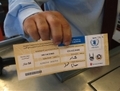 Un commerçant présente un bon d’alimentation du PAM dans un supermarché jordanien. (WFP/Jean-Philippe Chauzy) 