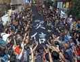 Hong Kong, 14 septembre 2014: 4 000 sympathisants du mouvement Occupy Central à Hong Kong ont participé à la «marche du tissu noir» au cours de laquelle tous portaient des tee-shirts noirs et des nœuds jaunes et ont déployé une banderole noire de 450 mètres. (Pan Zaishu/Epoch Times)
