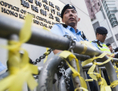 9 novembre 2014: des policiers barrent l’accès au Bureau de liaison de Hong Kong. Des centaines de manifestants pro-démocratie, y compris les dirigeants du mouvement qui a bloqué les rues depuis des semaines, se sont rassemblés près du Bureau de liaison pour appeler au dialogue avec les responsables de Pékin. (Xaume Olleros/AFP/Getty Images)
