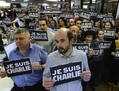 Les journalistes de l’Agence France Presse portant des pancartes «Je suis Charlie» pendant leur minute de silence le 7 janvier 2015 dans leurs locaux (BERTRAND GUAY/AFP/Getty Images)