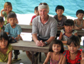 Le PDG d’Angkor Gold, Mike Weeks, est assis avec des enfants qui fréquentent une des écoles construites par sa compagnie au Cambodge. (Gracieuseté d’Angkor Gold)
