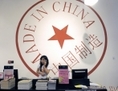 18 juin 2009: une femme est au téléphone derrière le comptoir d’un magasin à Pékin. Derrière elle est affiché un logo «made in China» (fabriqué en Chine). La classe moyenne chinoise évite les produits fabriqués en Chine et préfère consommer les nombreuses marchandises étrangères qu’elle ramène de ses voyages. (Liu Jin/AFP/Getty Images)
