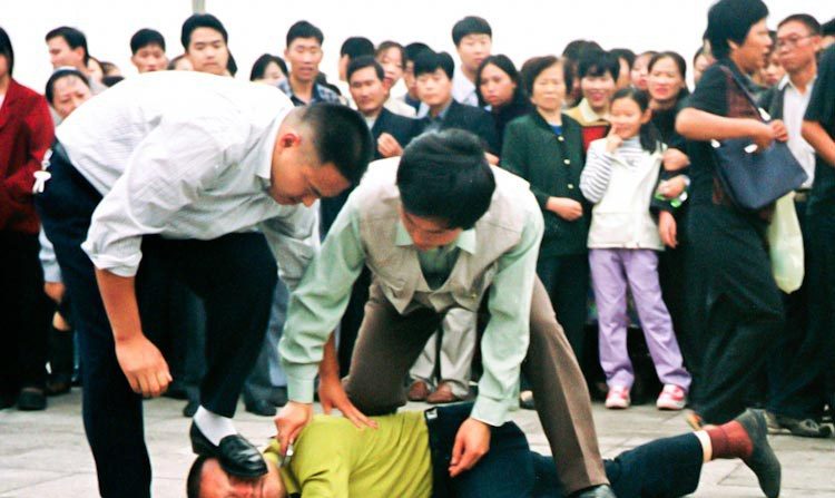 La tyrannie en action. La police chinoise en uniforme et en civil arrêtent des pratiquants de Falun Gong venus à la place Tiananmen faire un appel pacifique pour la fin de la persécution le 25 juillet 2001. (Clearwisdom)