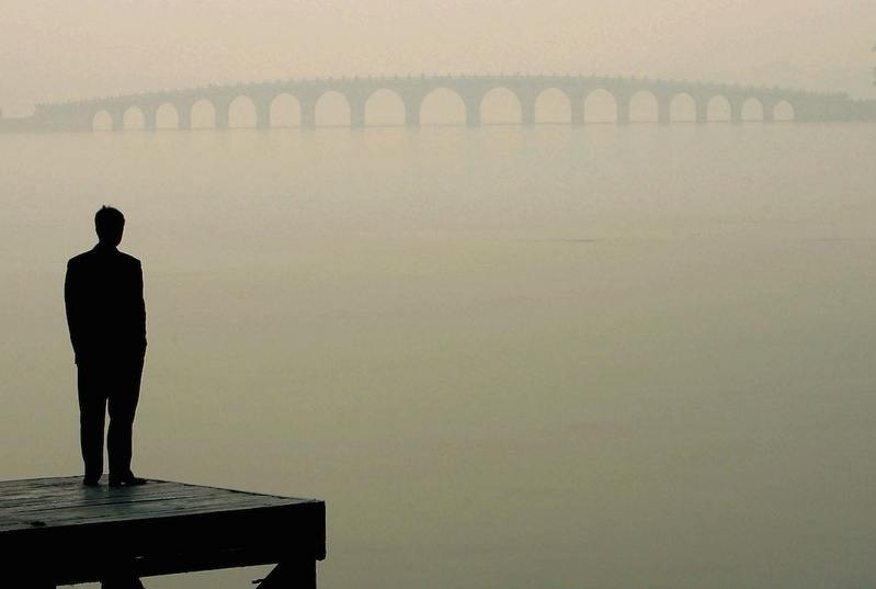 Un homme observe un pont dans l’épais brouillard de Pékin. (Guang Niu/Getty Images)