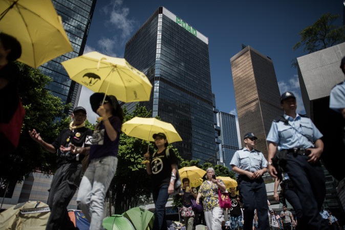 17 juin 2015: des manifestants pour la démocratie défilent devant les bâtiments du pouvoir législatif à Hong Kong en tenant des parapluies jaunes lors d'un rassemblement contre le programme électoral controversé proposé par les autorités de Pékin. (Philippe Lopez/AFP/Getty Images)
