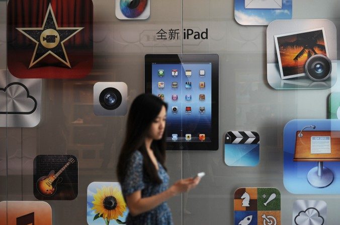Une cliente passe devant une boutique Apple, à Shanghai, en 2012. La nouvelle loi chinoise sur la cybersécurité restreint les sociétés comme Apple et peut entraver la propre économie de la Chine. (Peter Parks/AFP/Getty Images)
