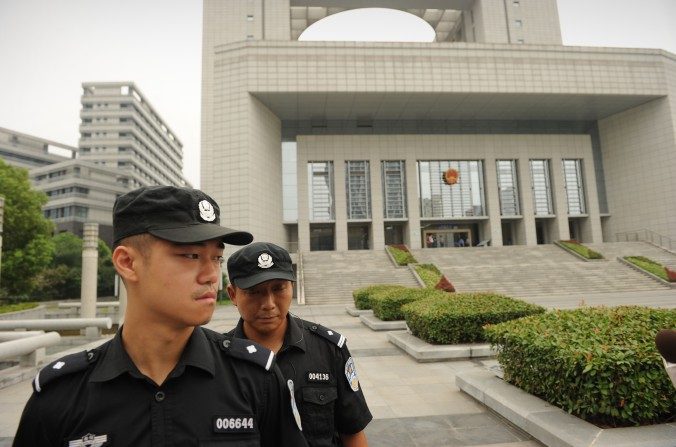 Des policiers montent la garde à l'extérieur de la Cour populaire intermédiaire de Hefei, dans la province de Anhui, en Chine, le 20 août 2012. (PETER PARKS / AFP / GettyImages)