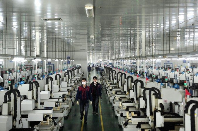 Des employés travaillant dans un atelier de l’entreprise Lens Technology de Liuyang dans la province du Hunan au centre de la Chine, le 12 mars 2015. (STR / AFP / Getty Images)