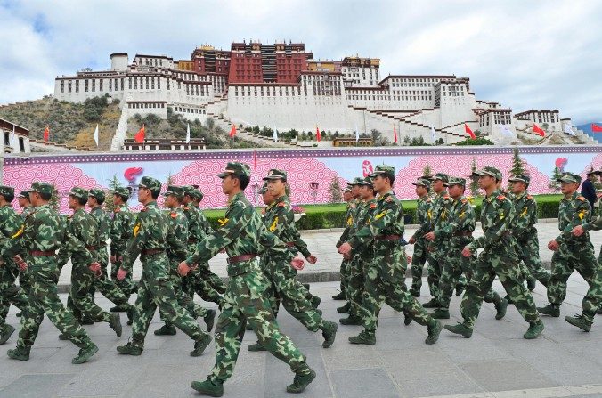 Une patrouille chinoise de policiers paramilitaires, devant le Palais du Potala (Tibet) à l'occasion de la cérémonie du passage de la torche à Lhasa, pendant les Jeux olympiques de Pékin, le 21 juin 2008. (Teh Eng Koon/AFP/Getty Images)